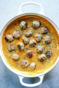 Meatballs in creamy sauce in a white cast iron pan