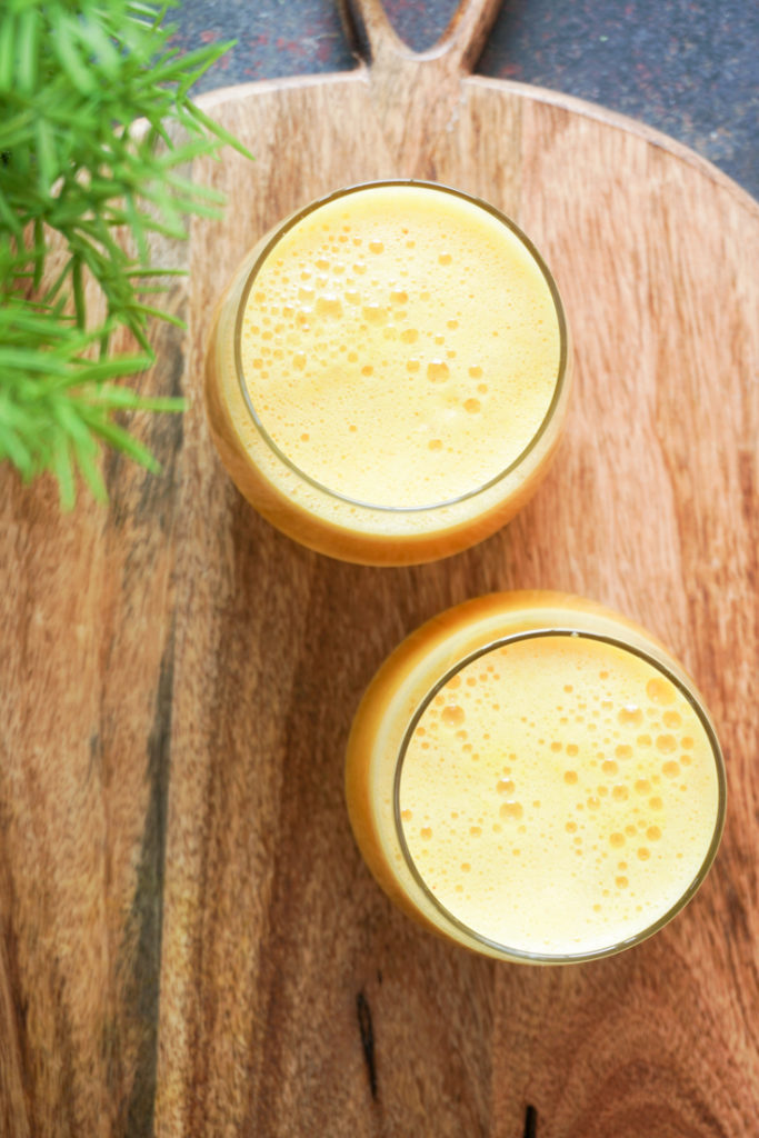 Top shot of two glasses of immunity boosting juice on a wood board