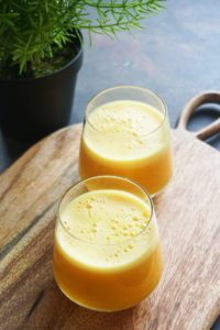 Two glasses of immunity boosting juice on a wood board