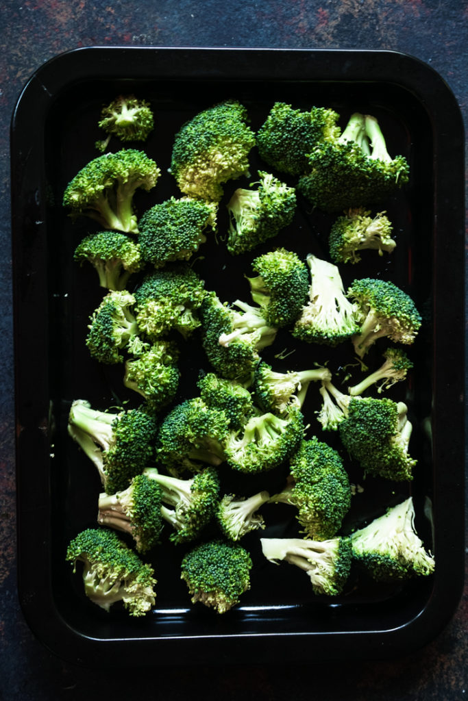 Broccoli florets in a black sheet pan