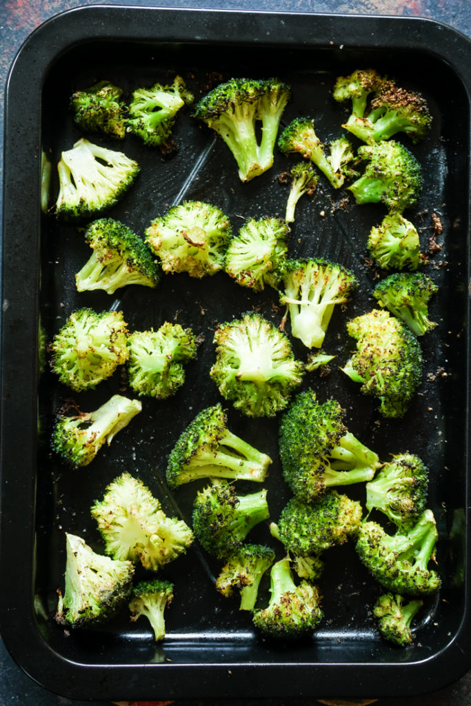 Roasted broccoli in a black sheet pan