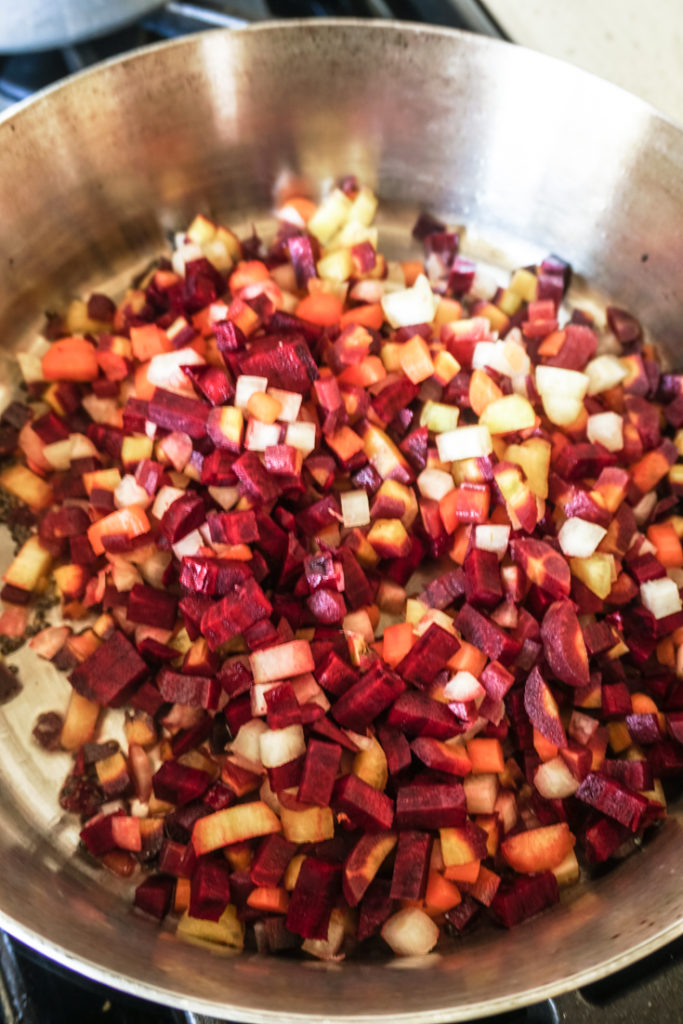 Chopped beets and carrots in a stainless steel pan