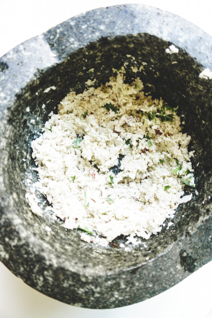 Crushed coconut and green chillies in a mortar