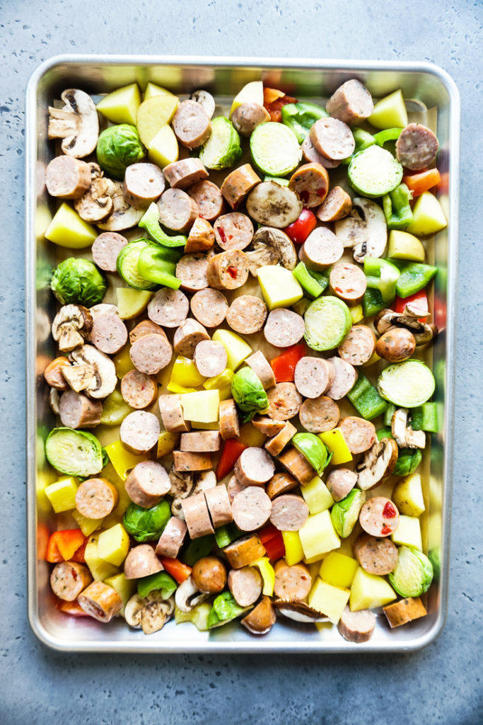 sausage and veggies lined up in a sheet pan