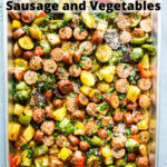 Cooked sausage and vegetables in a sheet pan with text on top of the image