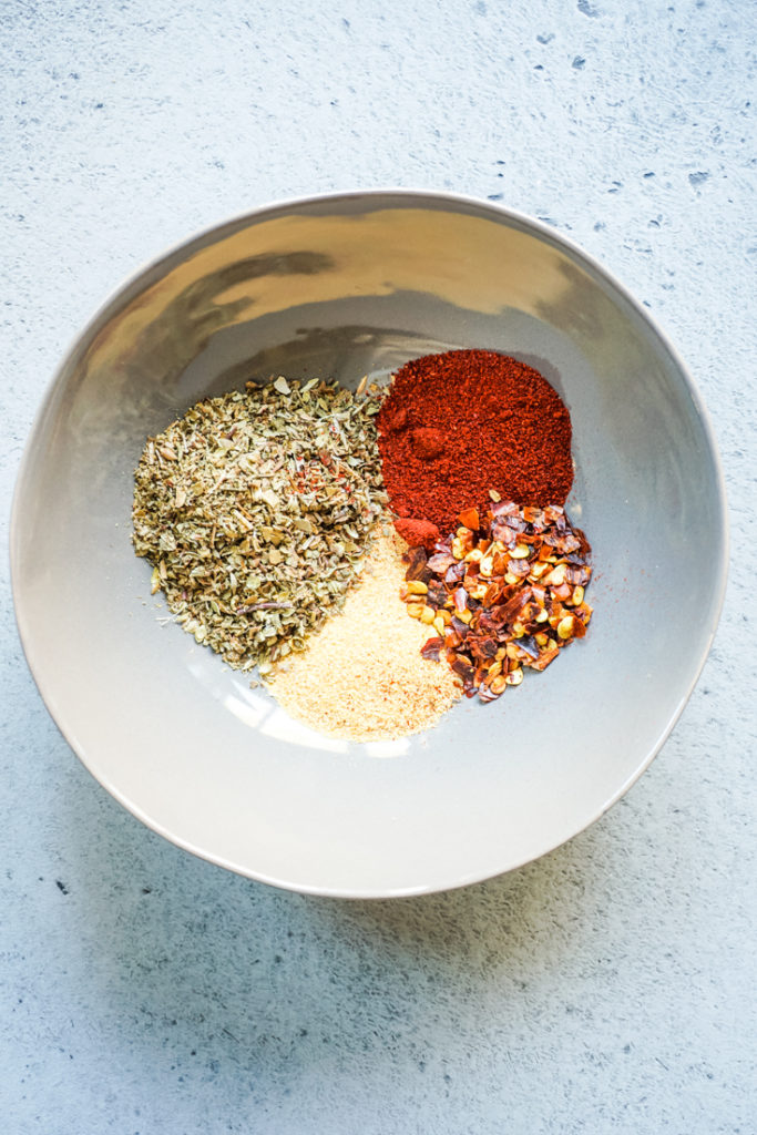 Spices in a grey bowl for sheet pan sausage and veggies