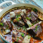 Angle shot of short ribs curry in a white dutch oven