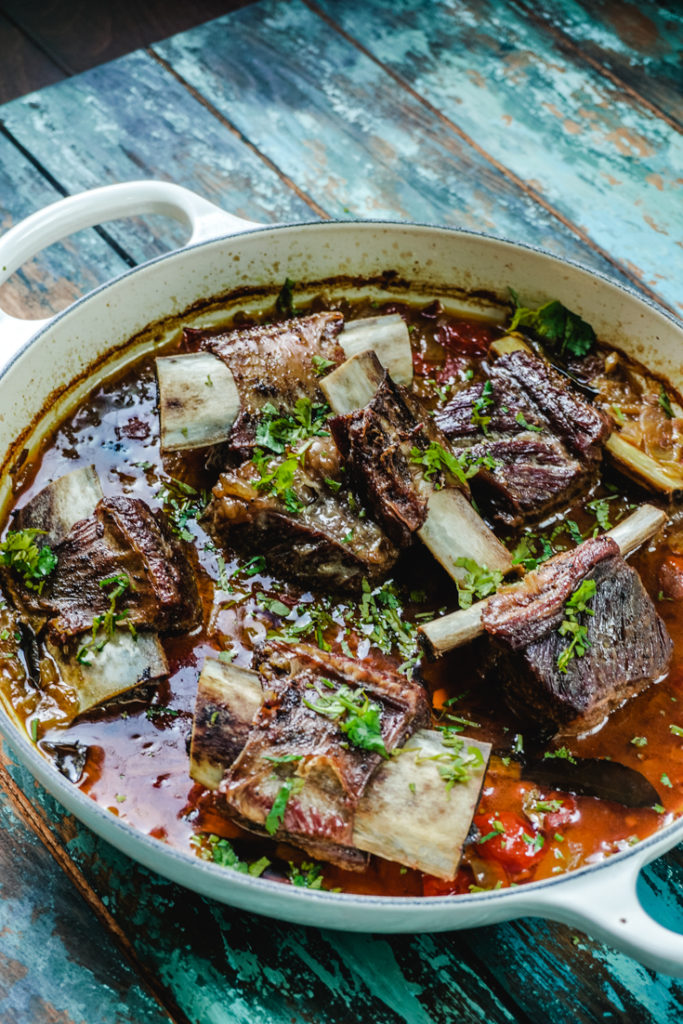 Angle shot of short ribs curry in a white dutch oven