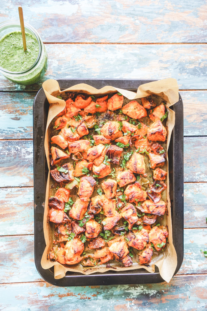 Sheet pan with cooked chickena nd vegetables sprinkled with cilantro on top