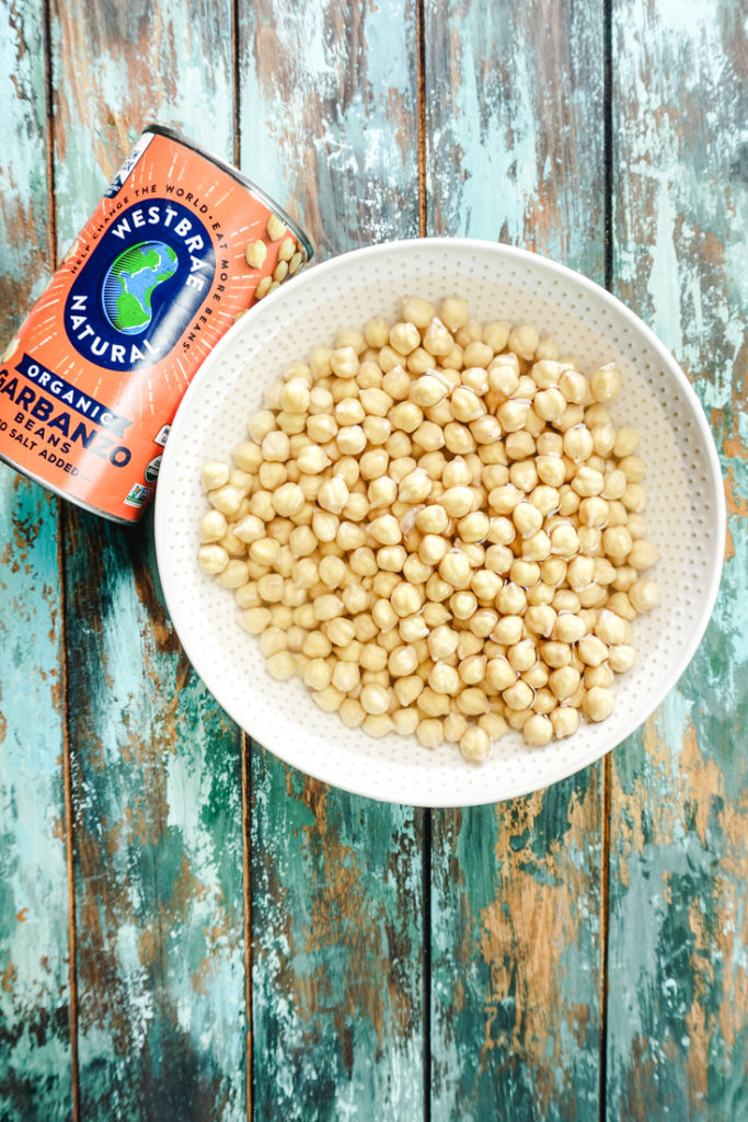 cooked chickpeas in a bowl with a can of chickpeas on the side