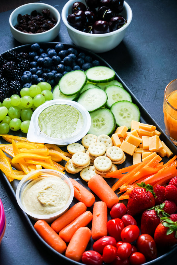 Angle shot of a snack board with rainbow colored snacks in it