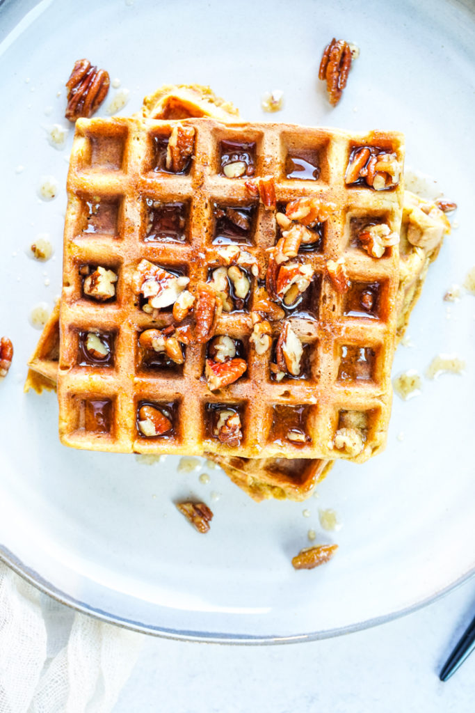 Two waffles stacked on top of each other on a grey plate