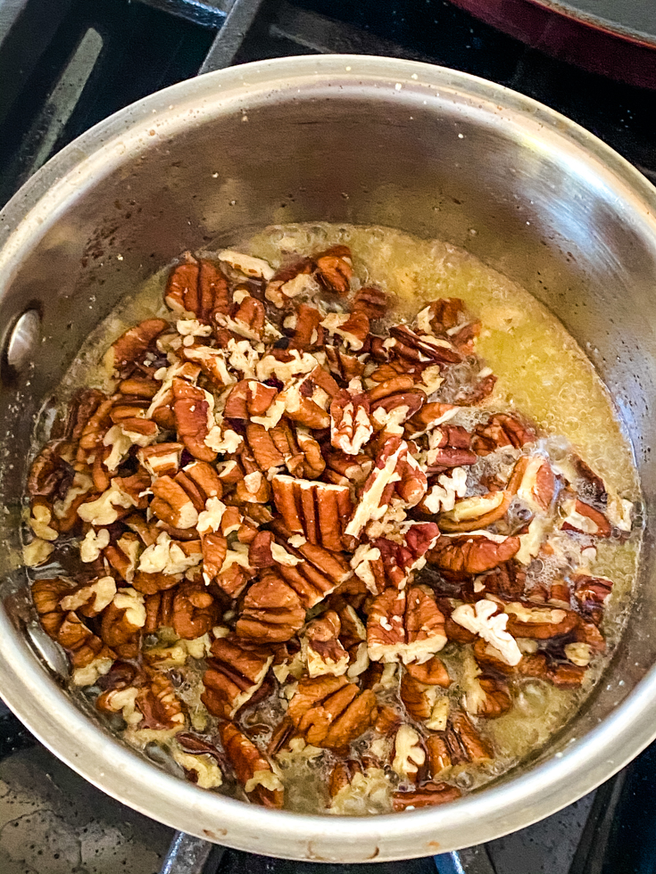 Chopped pecans in melted butter in a saucepan
