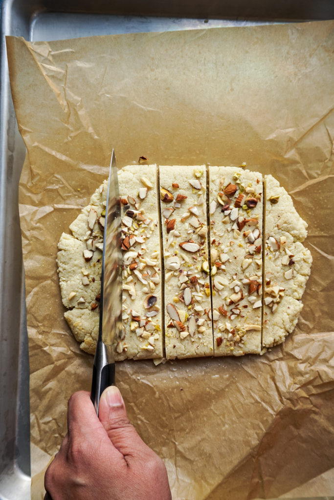 Knife cutting the burfi into squares