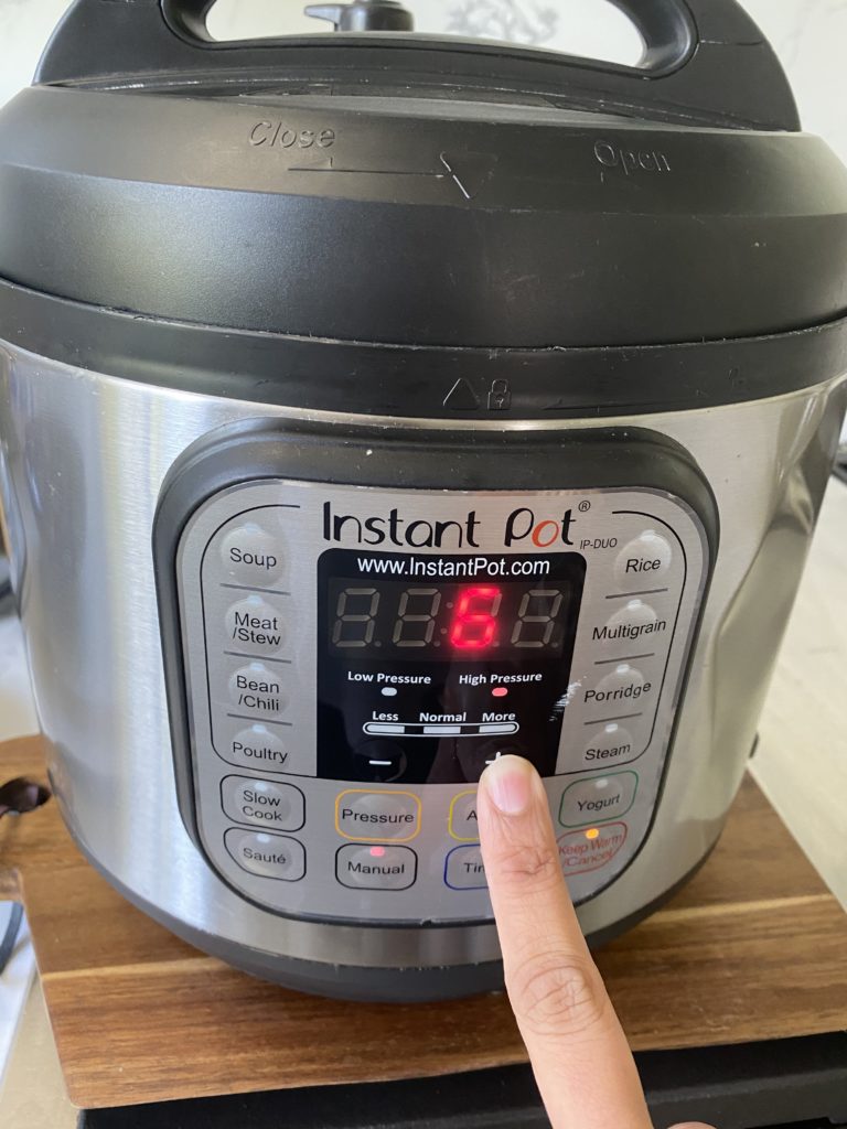 Instant Pot with display 6 showing on it and a finger on the + button
