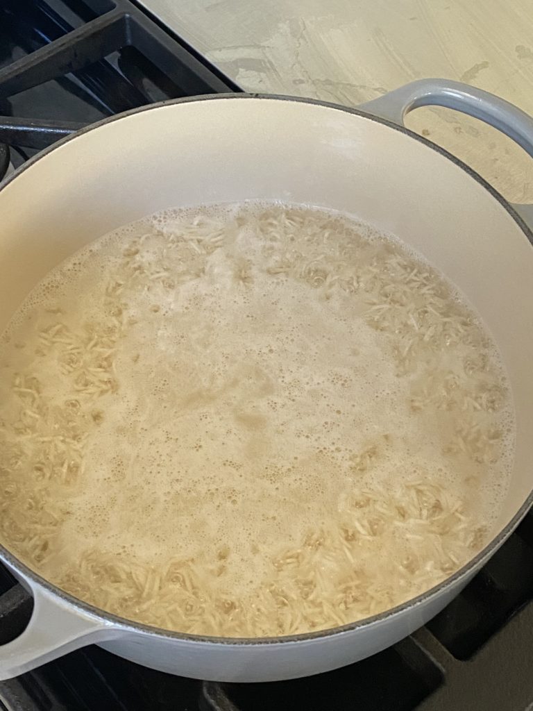basmati rice and water boiling in a dutch oven