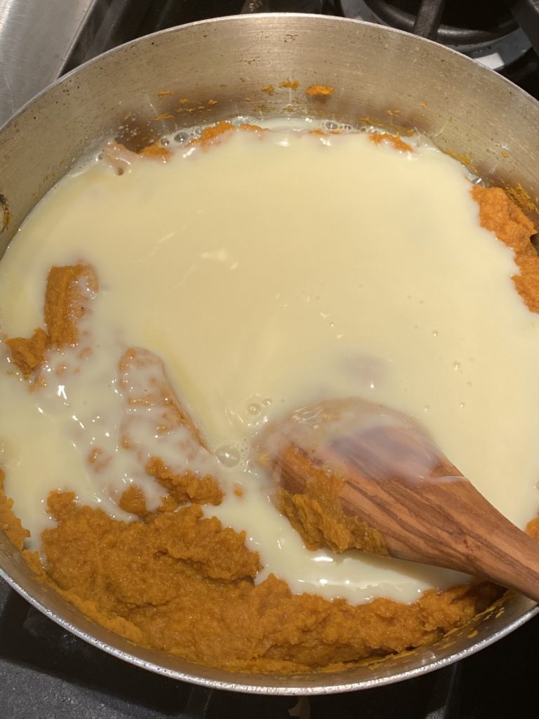 Condensed milk added to pumpkin in the pan