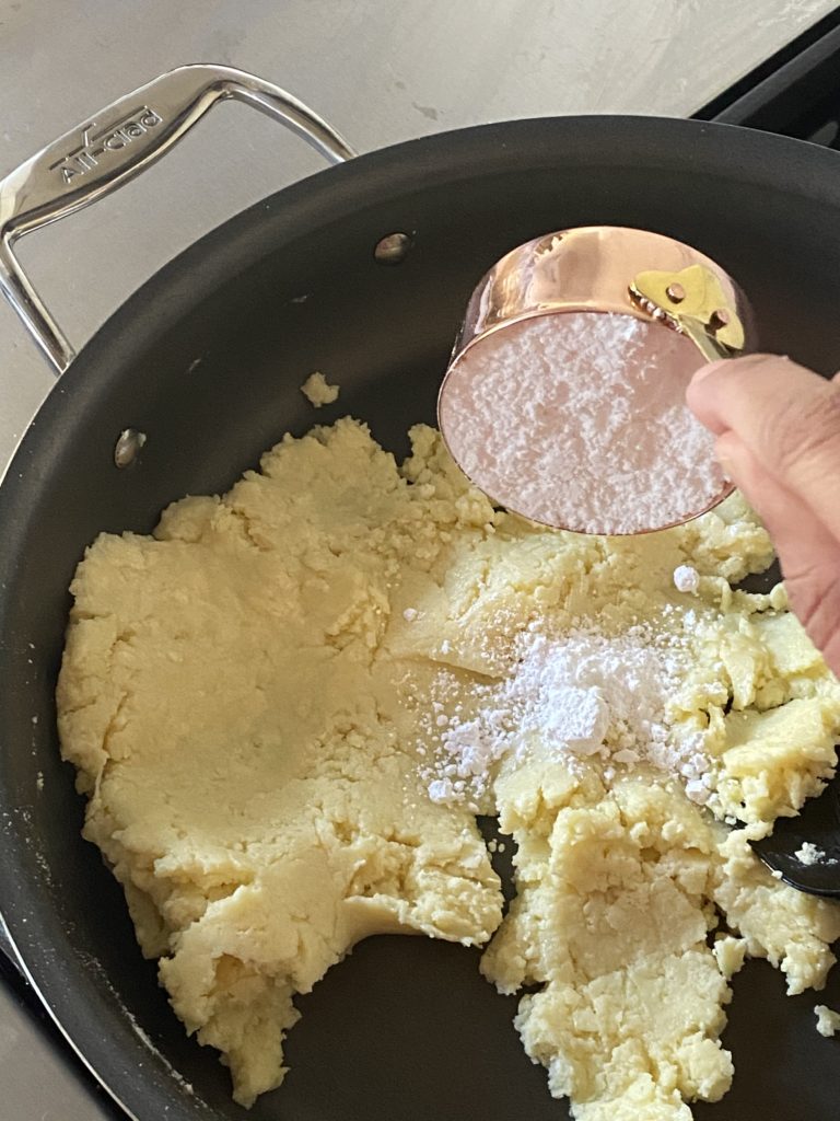 powdered sugar being added to the milk powder mixture