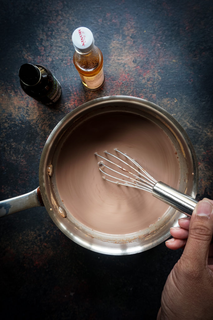 hand whisking hot chocolate in a saucepan
