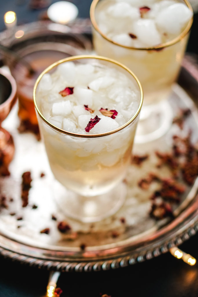 cardamom rose cocktail in two gold rimmed glasses on a silver platter