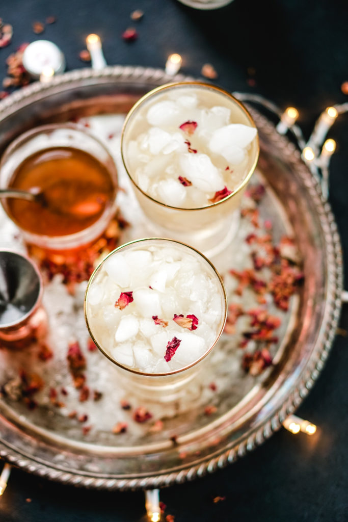cardamom rose cocktail in two gold rimmed glasses on a silver platter