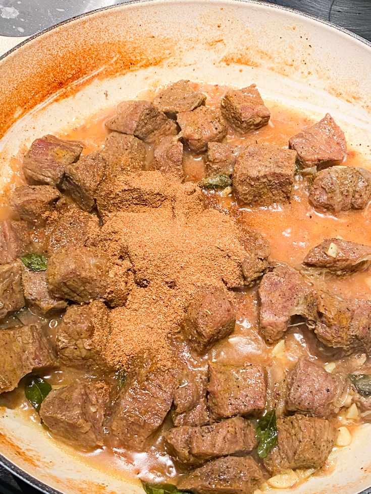 spice powder on top of beef fry in pot
