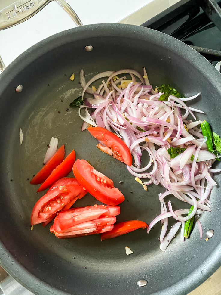 onions and tomatoes in a saute pan