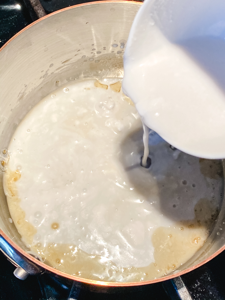 coconut milk being added to jaggery in a saucepan