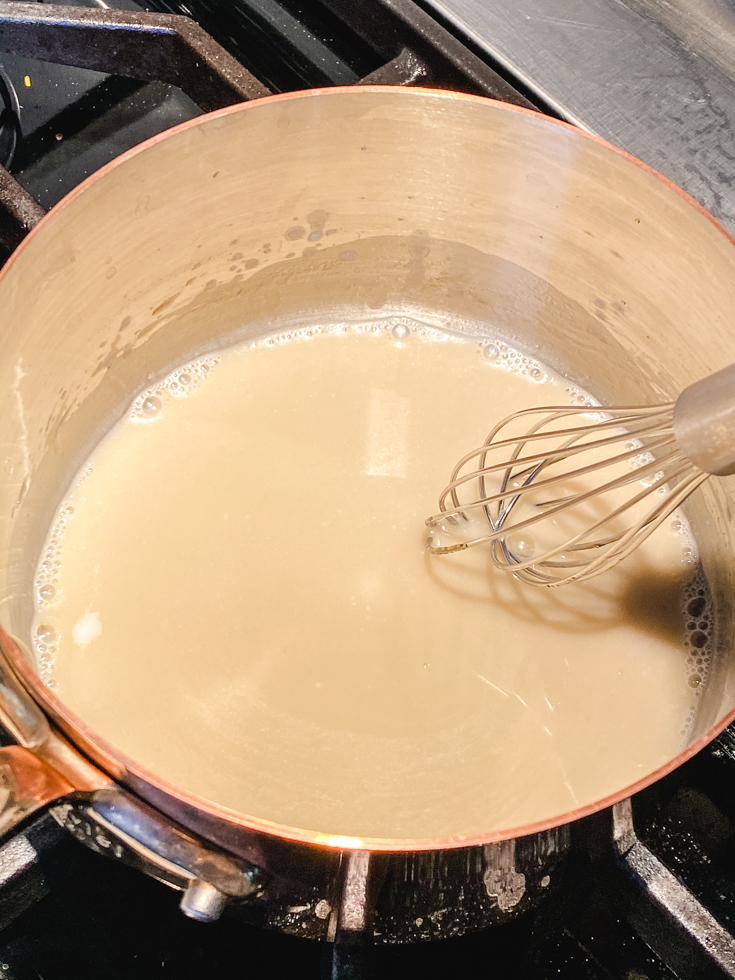 whisking coconut milk and jaggery in a saucepan