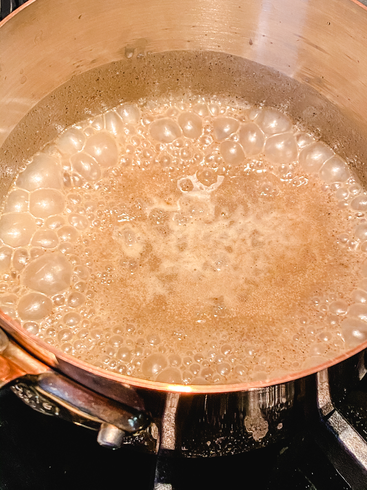 coconut jaggery caramel bubbling in a saucepan