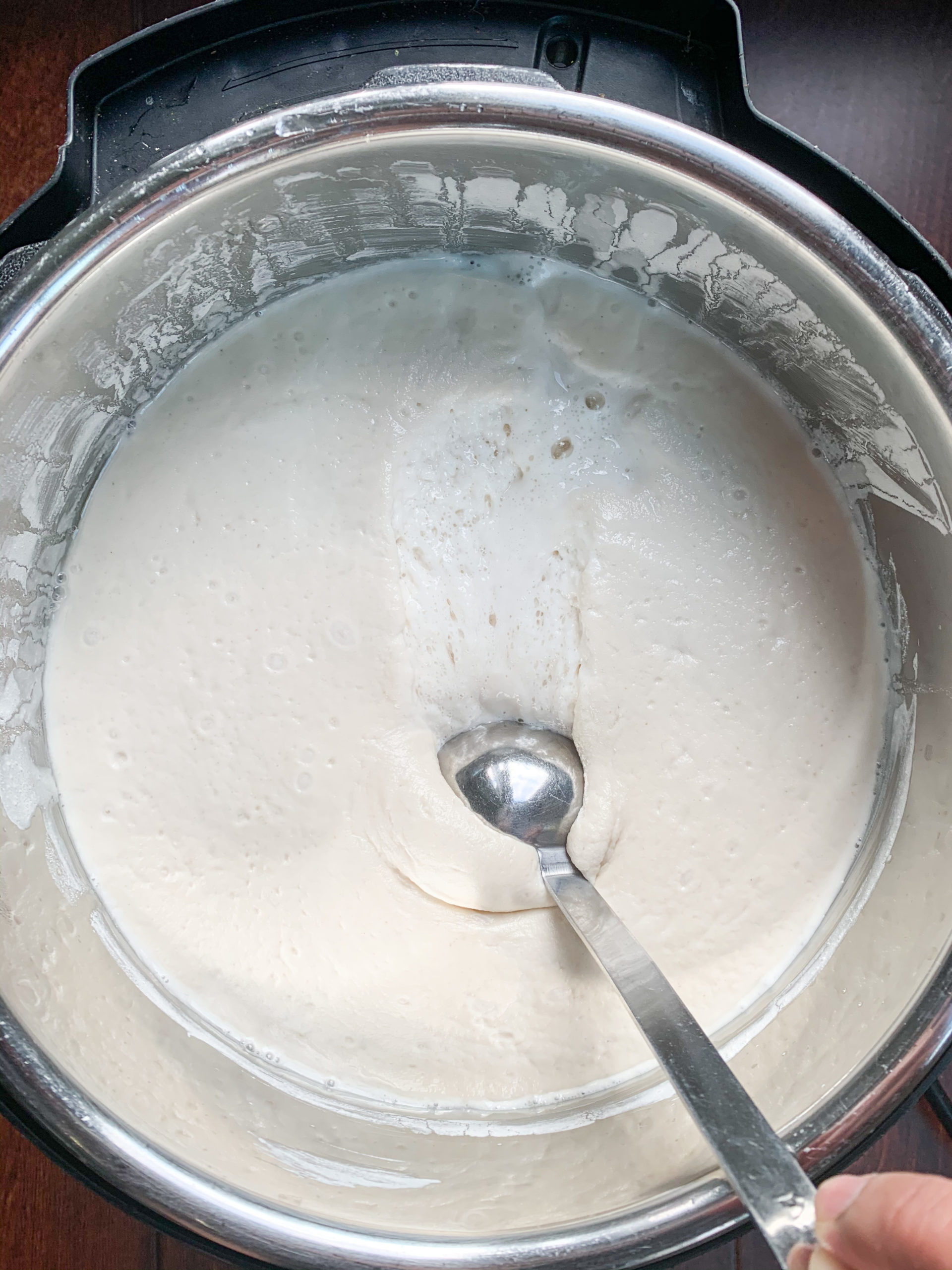Idli batter in a pot with a ladle in it