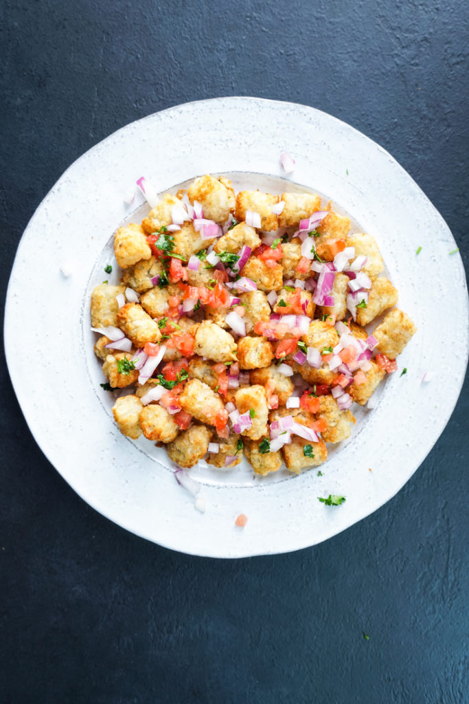 tater tots chaat on a white platter