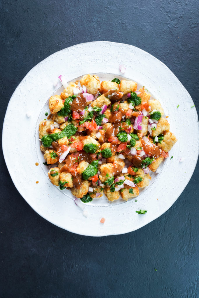 tater tots chaat on a white platter