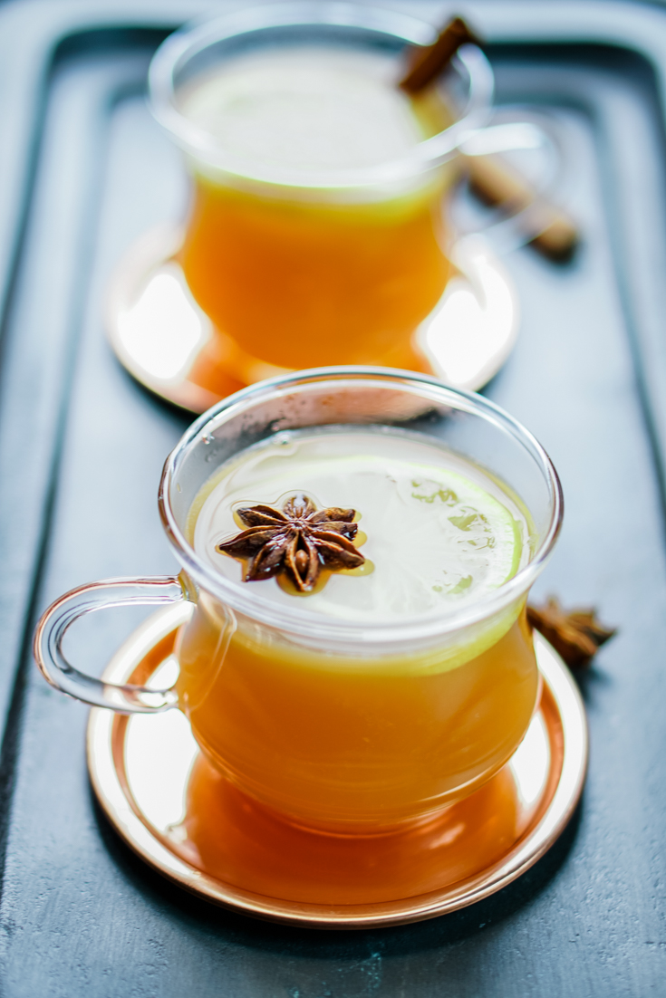 two glass cups on brass coasters with hot toddy