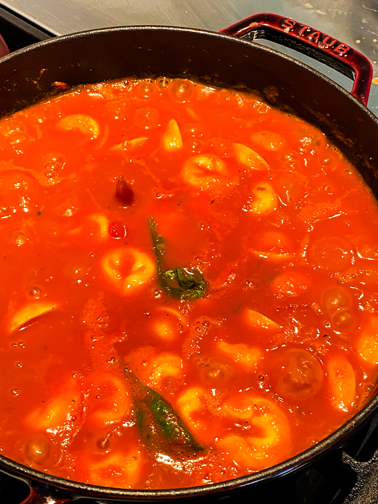 Tomato basil tortellini soup in a Dutch oven