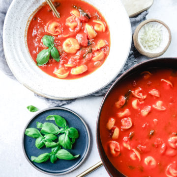 tomato basil tortellini soup in a bowl and Dutch oven