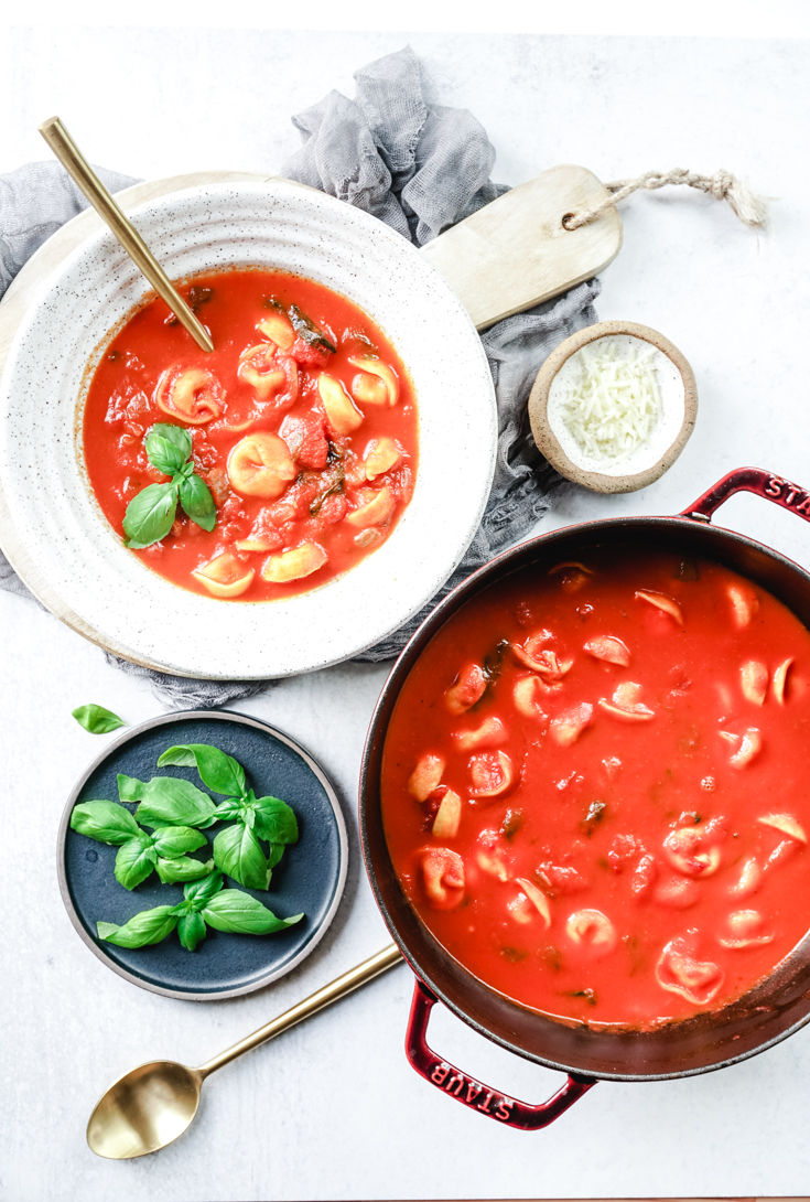 tomato basil tortellini soup in a bowl and Dutch oven