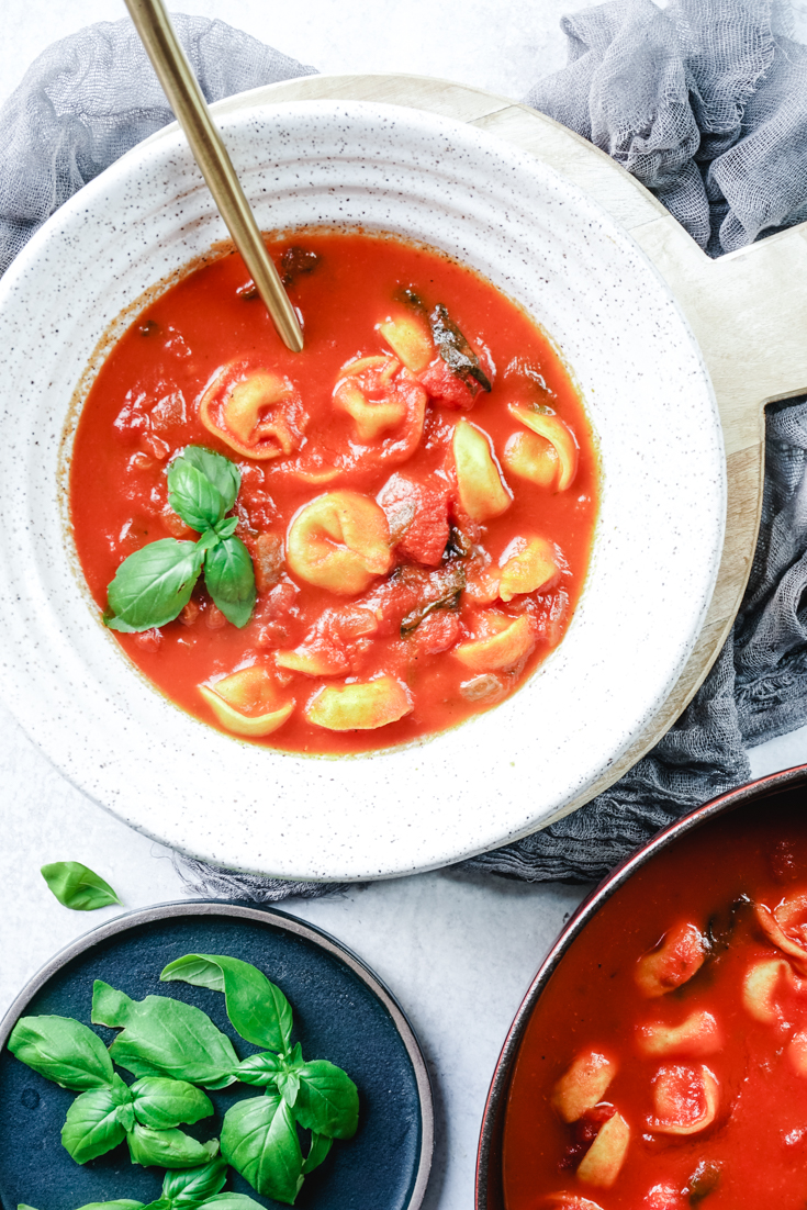 tomato basil tortellini soup in a bowl and Dutch oven