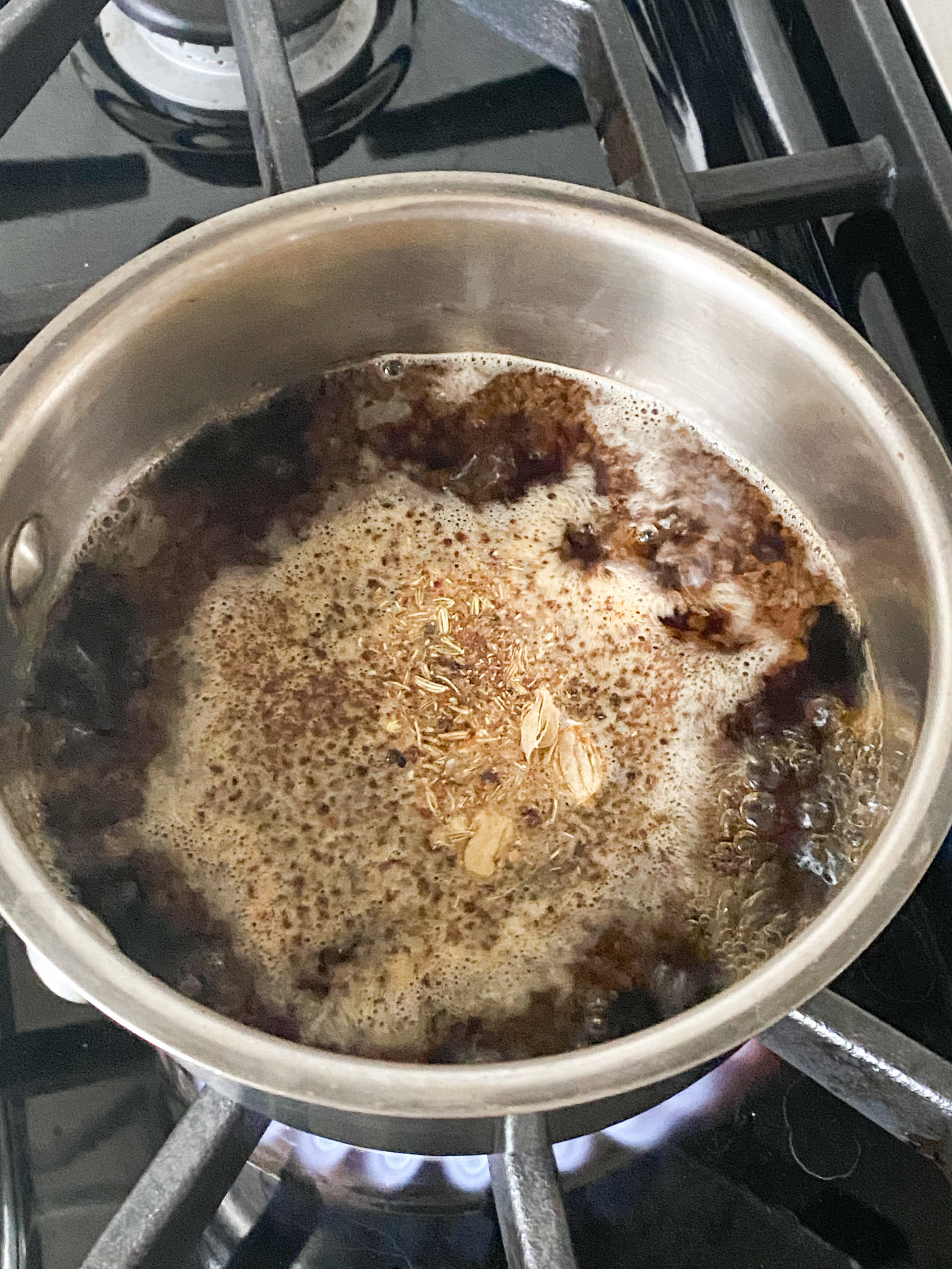 tea leaves and spices boiling together in water in a saucepan