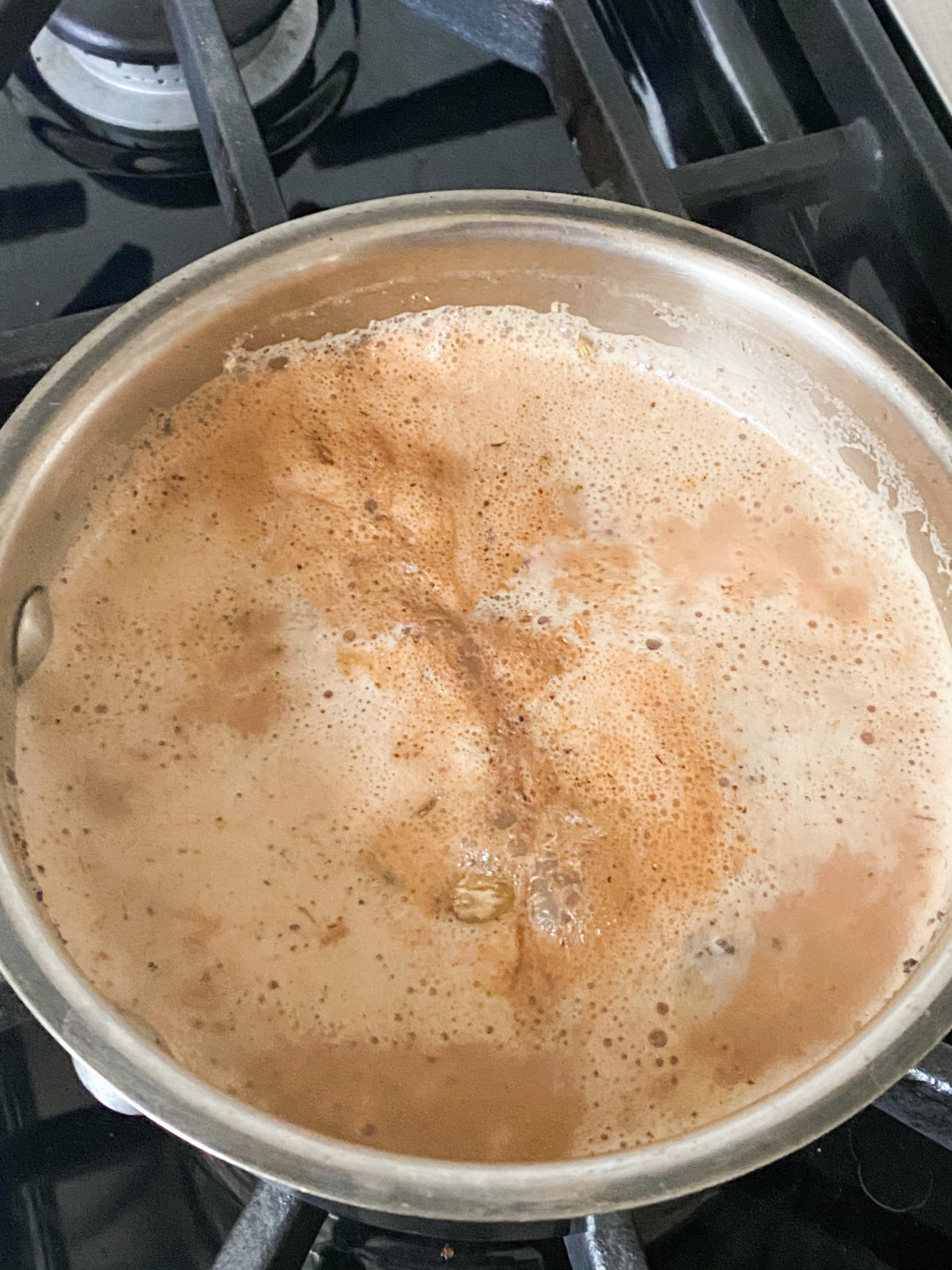 Indian chai with milk simmering in a saucepan