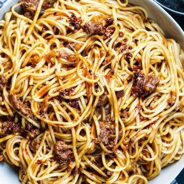 spicy pork noodles in a white bowl