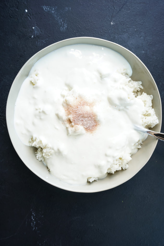 curd and salt added to rice in a bowl