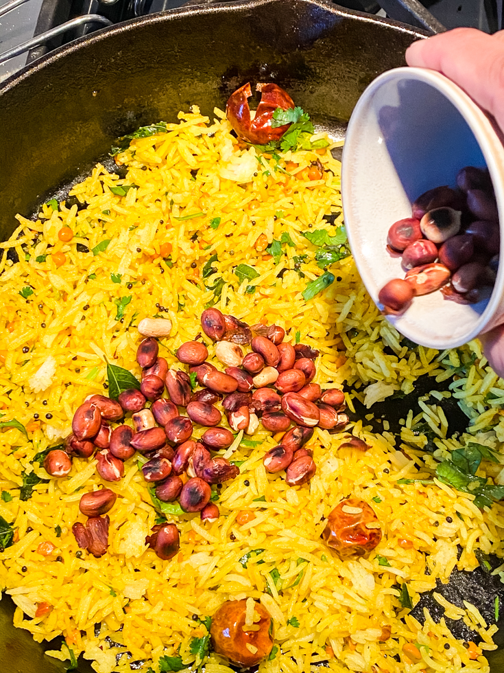 peanuts over lemon rice in a skillet