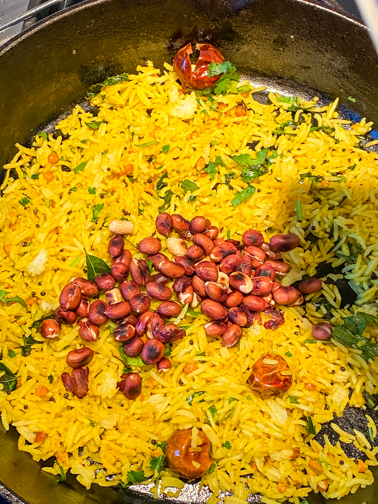 peanuts over lemon rice in a skillet