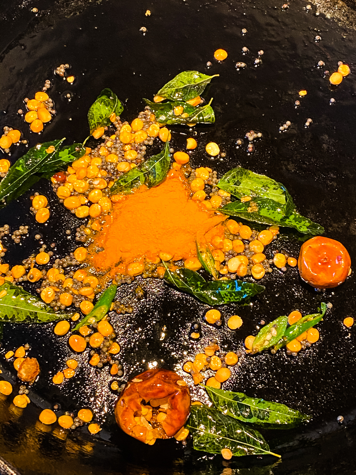 turmeric powder, curry leaves and lentils in a skillet