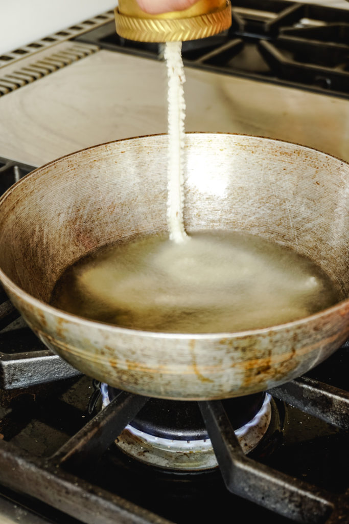 murukku dough being squeezed into the hot oil