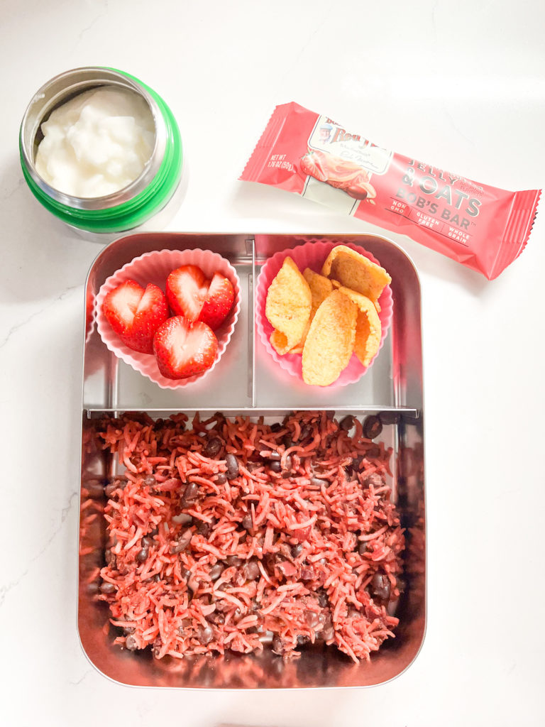 Kids lunch box with valentines themed food, a cereal bar and a bowl of yogurt