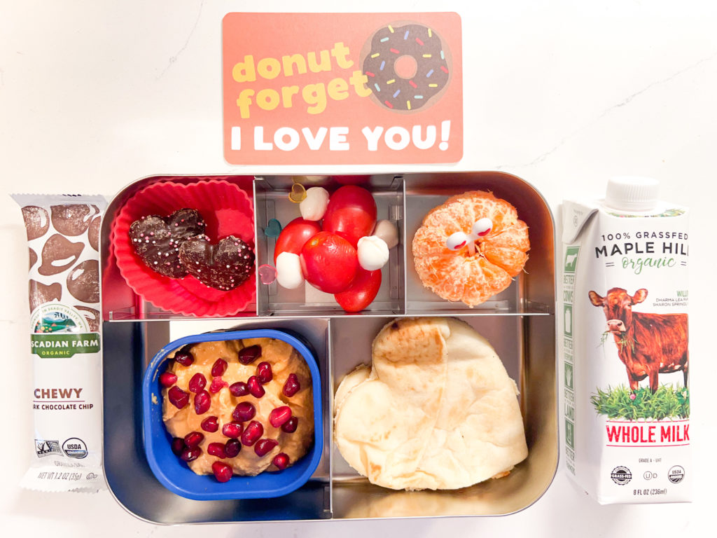 Kids lunch box with valentines themed food, cereal bar and a lunch box note