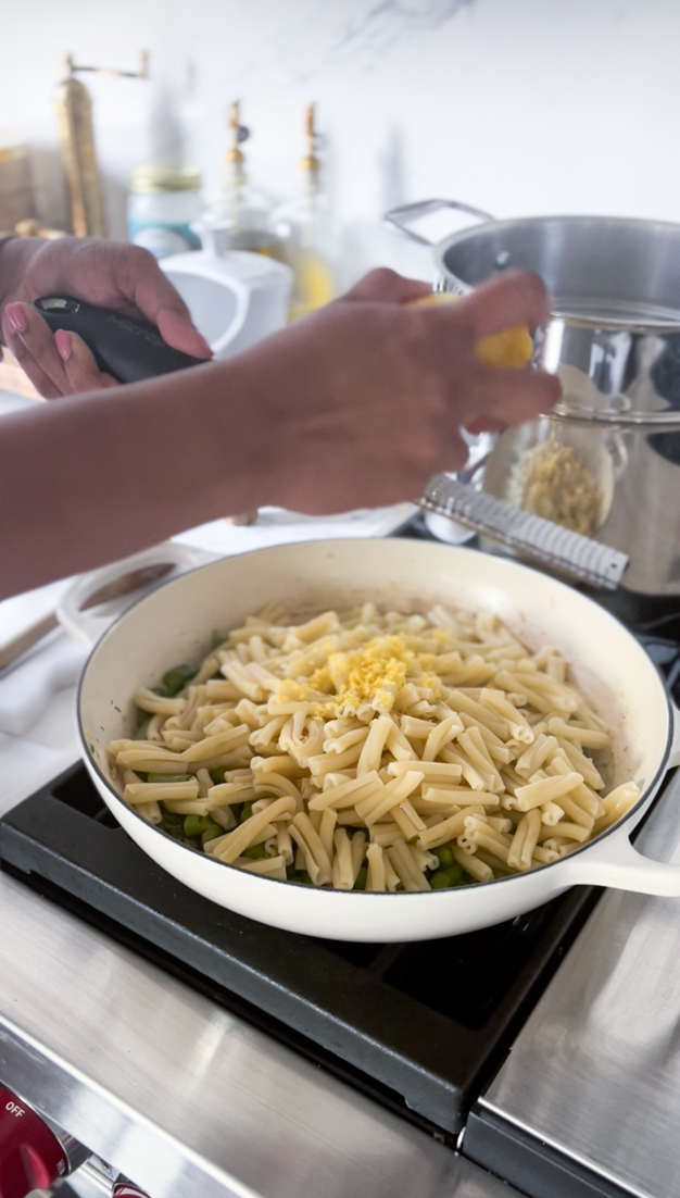 lemon being zested on to pasta