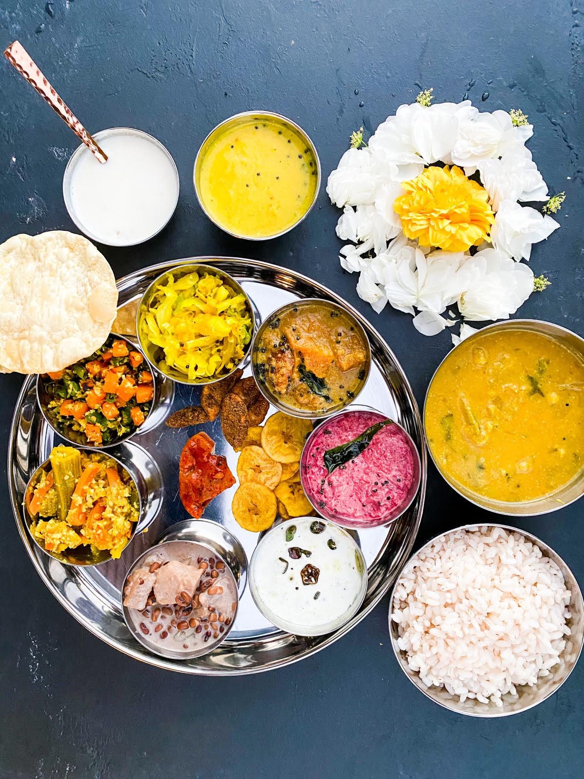 Several dishes in small steel containers on a steel plate